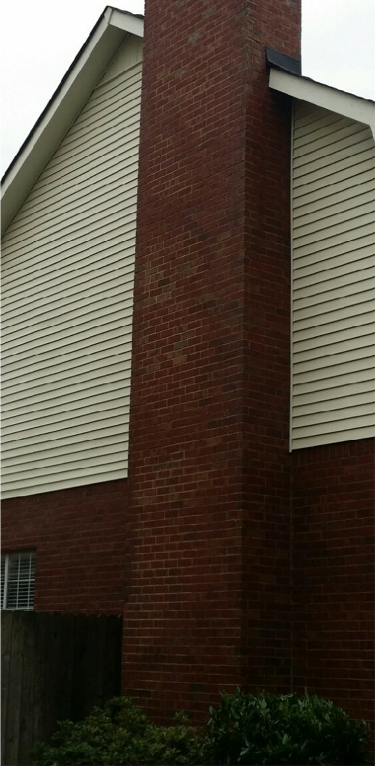 The same brick and siding wall after soft washing