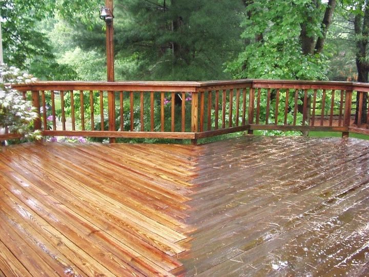 Deck boards half cleaned, showing gray weathered wood next to restored natural wood