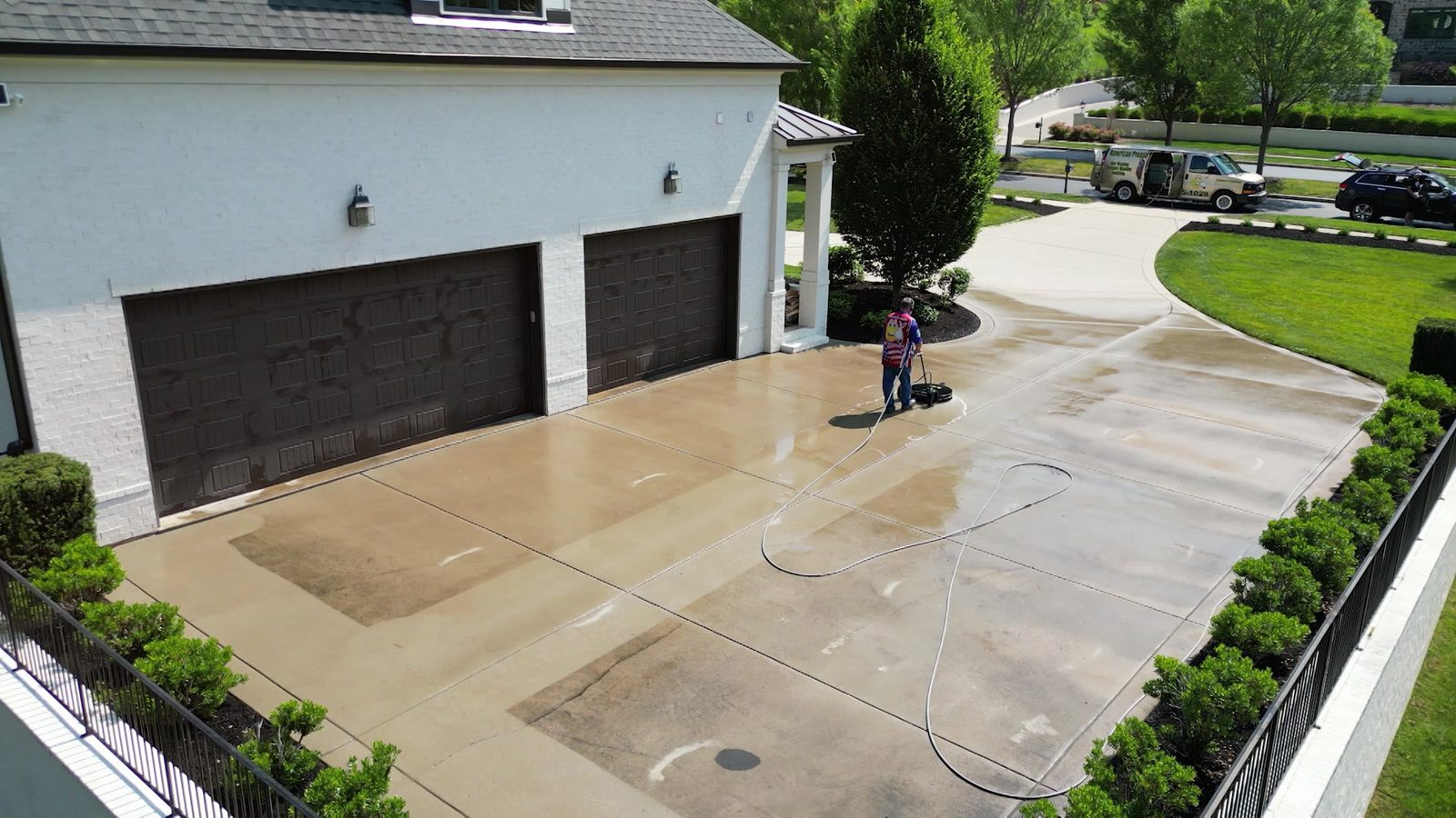 Clean concrete driveway in front of a brick garage after pressure washing