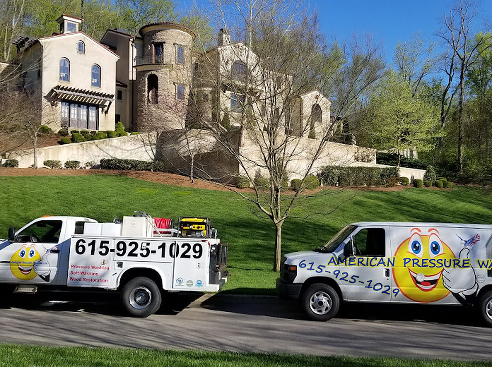 Two American Pressure Washing trucks parked in front of a stone home in Brentwood TN